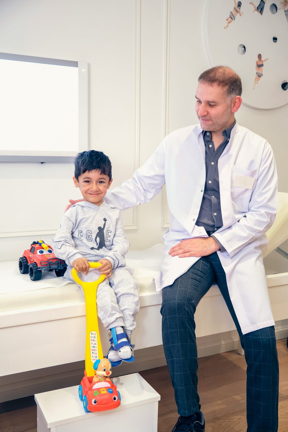 A doctor seeing a young patient in a bright clinic room